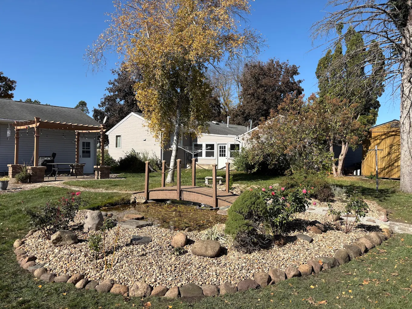 Backyard landscape with stone-edged garden and pond